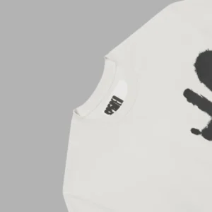 Close-up of the Sp5der 5Luminum Tee in ivory featuring the iconic black spray-paint graphic and inner neck branding.