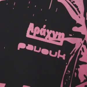 Close up view of the Sp5der Jersey Overprint Tee showing pink graphic details and text printed on black fabric.