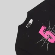 Close-up of the black Sp5der Pavouk Rhinestone Tee showing the pink graphic "5" and sparkling web detail.