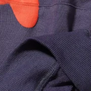 Close up view of the premium navy blue fabric and red print detail on the Sp5der Beluga Hoodie for men and women.