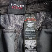 Close-up view of the interior fabric care label and branding on the Sp5der Active TECH performance shorts.