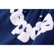 Close-up view of the white Sp5der Worldwide OG Web Logo graphic printed on navy blue premium sweat shorts fabric.