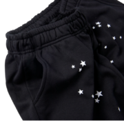 Close-up view of the Sp5der Souvenir SP5 black sweatpants featuring a stylish white star pattern and pocket detail.