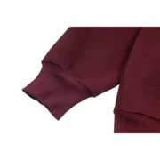 Close-up view of the sleeve cuff on the premium maroon Sp5der Nocturnal Highway Hoodie, showcasing fabric quality.