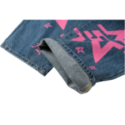 Detailed view of the Sp5der 5Star Vintage 501 Denim cuff showcasing pink star prints on high-quality blue fabric.