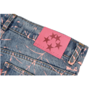 Close-up of Sp5der AOP Vintage 501 Denim Jeans featuring the distinctive pink branded leather back patch and print.