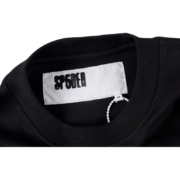 Detail view of the branded interior neck tag inside the black SP5DER Jeff Free T-shirt for authentic streetwear style.