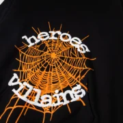 Sp5der x Metro Boomin Heroes and Villains hoodie featuring iconic orange web graphic detail on black fabric.