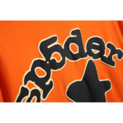 Close-up view of the Sp5der Worldwide Star graphic detail on the orange Beluga colorway streetwear t-shirt.