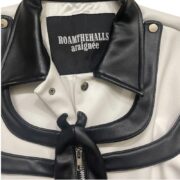 Detailed close-up of the Roam The Halls Sp5der jacket neck tag featuring high-quality leather and premium branding.
