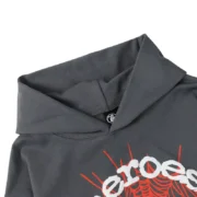 Close up detail view of the Sp5der x Heroes and Villains hoodie featuring a dark grey fabric and bold graphic design.