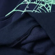 Detail of the premium navy blue Sp5der OG Web hoodie featuring the iconic signature green web graphic on the chest