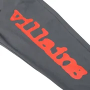 Close-up detail view of the Sp5der x Heroes and Villains sweatpants featuring a bold red graphic print on dark fabric.
