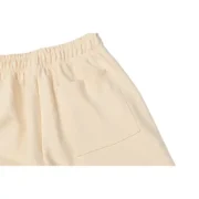 Detail view of the pocket and elasticated waistband on the premium Sp5der Cropped Sweatpant in a versatile cream color.