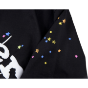 Close-up view of the sleeve detail on the black Sp5der OG Web V2 T-shirt featuring colorful printed star graphics.