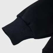 Detailed shot of the black Sp5der Worldwide Web hoodie sleeve showing the high-quality ribbed cuff design.