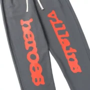 Close-up of grey Sp5der x Heroes and Villains sweatpants featuring high-quality red distressed graphic print detail.