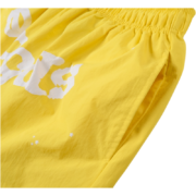 Close-up view of the side pocket and white web graphic on the vibrant yellow Sp5der OG Web Double Layer Shorts.