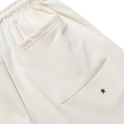 Sp5der x Mariah the Scientist Scorpion Sweatpants in cream featuring a detailed pocket and signature star logo graphic.