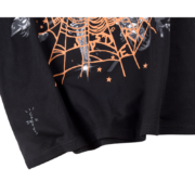 Close-up view of the SP5DER x Cactus Jack x ComplexCon exclusive black t-shirt featuring the unique orange web graphic print.