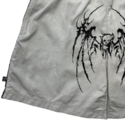 Close up view of the grey Sp5der print shorts featuring a distinctive black graphic design and elastic waistband.