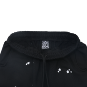 Black Sp5der Jeffery Sweatpant detail featuring an elasticated waistband, drawstring, and iconic star print design.