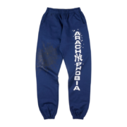 Front view of blue Sp5der Arach NY Phobia sweatpants with a bold white text graphic and arachnid motif design.