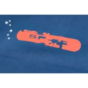Close-up view of the orange Sp5der logo detail on the front of a navy blue cropped hoodie for streetwear fans