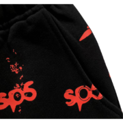 Close-up view of the black Sp5der Sex AOP sweatpants featuring a bold red all-over graphic print and quality fabric.