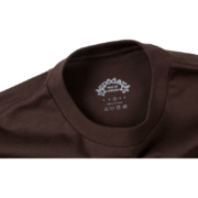 Close-up of the inner neck tag on the Sp5der OG Web Tee in a rich, earthy brown colorway from the official collection.