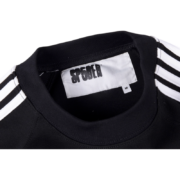A close-up view of the Sp5der logo neck label on the sleek black 5EX top, showing the high-quality garment branding.