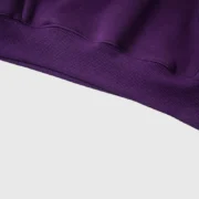 Close-up detail of the premium purple fabric and ribbed hem on the Sp5der Star OG Web V2 streetwear hoodie.