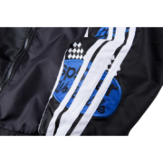 Close-up view of the sleeve branding on the black and blue Sp5der satin bomber jacket featuring athletic detailing.