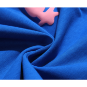 Close-up view of the premium fabric and iconic pink graphic on a Sp5der Worldwide Star blue T-shirt for streetwear.