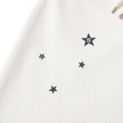 Close-up of the Sp5der x Mariah the Scientist cream sweatpants showcasing the iconic black star pattern detail.