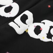 Close up view of the Sp5der OG Web Sweatpants featuring a white graphic print with colorful star details on fabric.