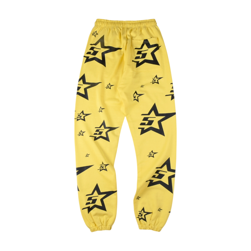 Sp5der 5Star sweatpants in a vibrant yellow colorway featuring a bold all-over black star graphic print for streetwear.