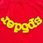 Close-up of the red Sp5der OG Logo Sweatshort featuring the iconic yellow graphic logo in a premium soft fabric.