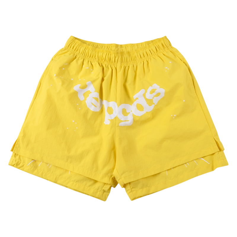 Front view of vibrant yellow Sp5der OG Web double-layer shorts featuring a white signature graphic design and elastic waist.