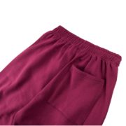 Close-up view of the back pocket detail on the burgundy SP5DER Nocturnal Highway cotton track pants for men and women