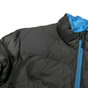 A close-up view of the Sp5der men’s light down puffer jacket featuring a sleek black design with bright blue trim.
