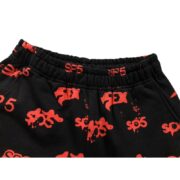 Close-up of Sp5der Sex AOP sweatpants with a black and red all-over print design and an elasticated waistband.