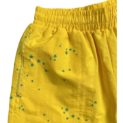 Vibrant yellow Sp5der sports shorts featuring a unique five-star print pattern and a side zipper pocket detail.