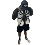 Model wearing the black and white Roam The Halls Sp5der jacket featuring a bold spider graphic design front view.