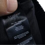 A close-up view of the interior tag on Spyder swim trunks board shorts detailing material composition and sizing info.