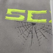 Close-up view of the Sp5der 5Ex Slate Grey fleece showing the signature puff print 5EX text and spider web graphic.