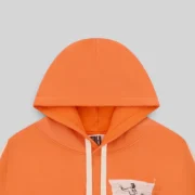 Close up view of the Sp5der 5star Rodeo Hoodie in vibrant orange, showcasing its heavyweight cotton fleece fabric.