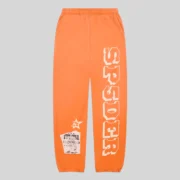 Front view of orange Sp5der 5Star Rodeo sweatpants featuring a large SP5DER logo print and a distressed patch design.
