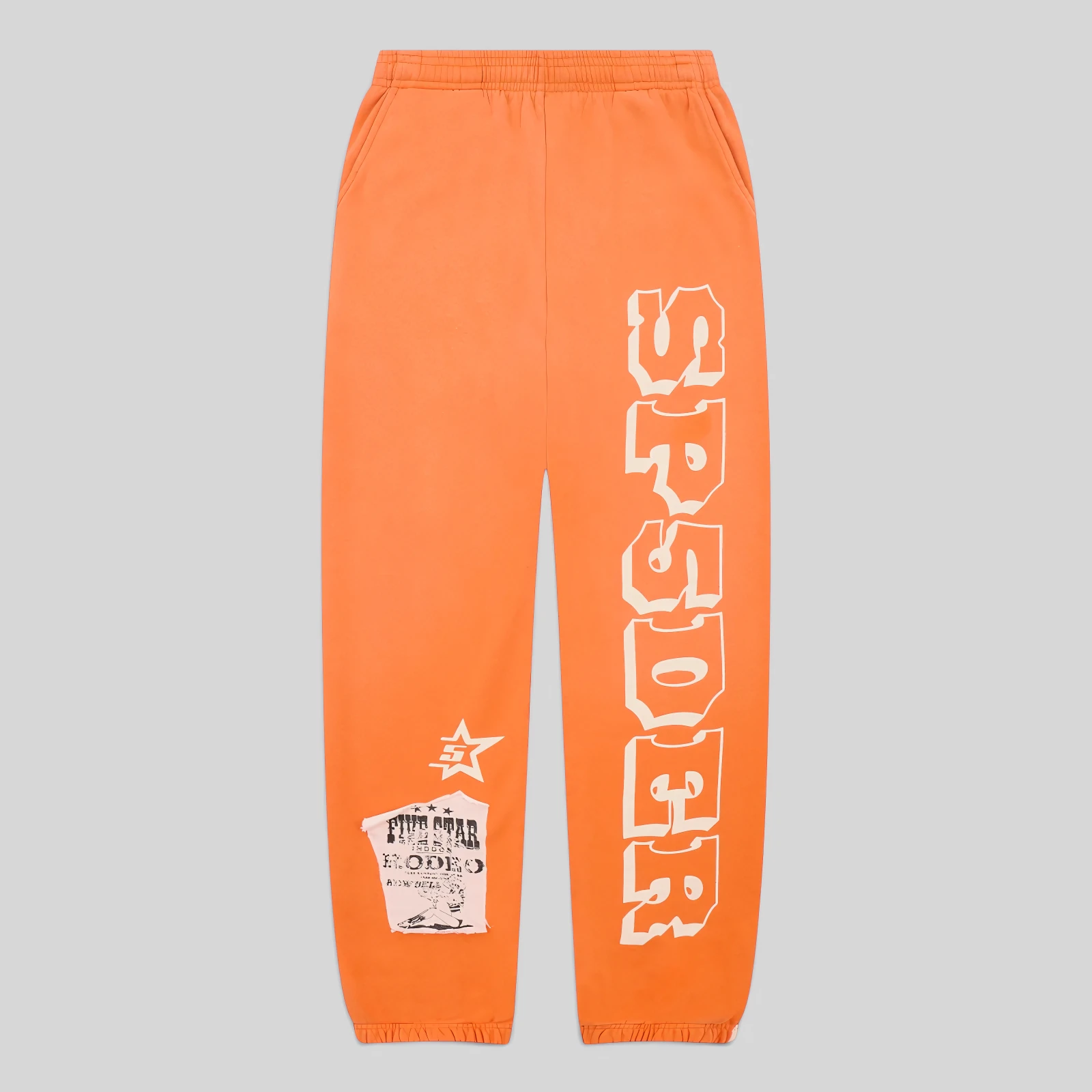 Front view of orange Sp5der 5Star Rodeo sweatpants featuring a large SP5DER logo print and a distressed patch design.