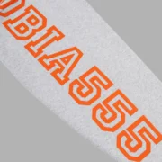 Close-up view of the bold orange graphic text detail on the sleeve of the Heather Grey Sp5der Arach hoodie.